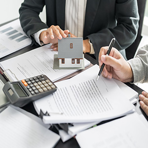 Business meeting with house model for real estate tax consulting